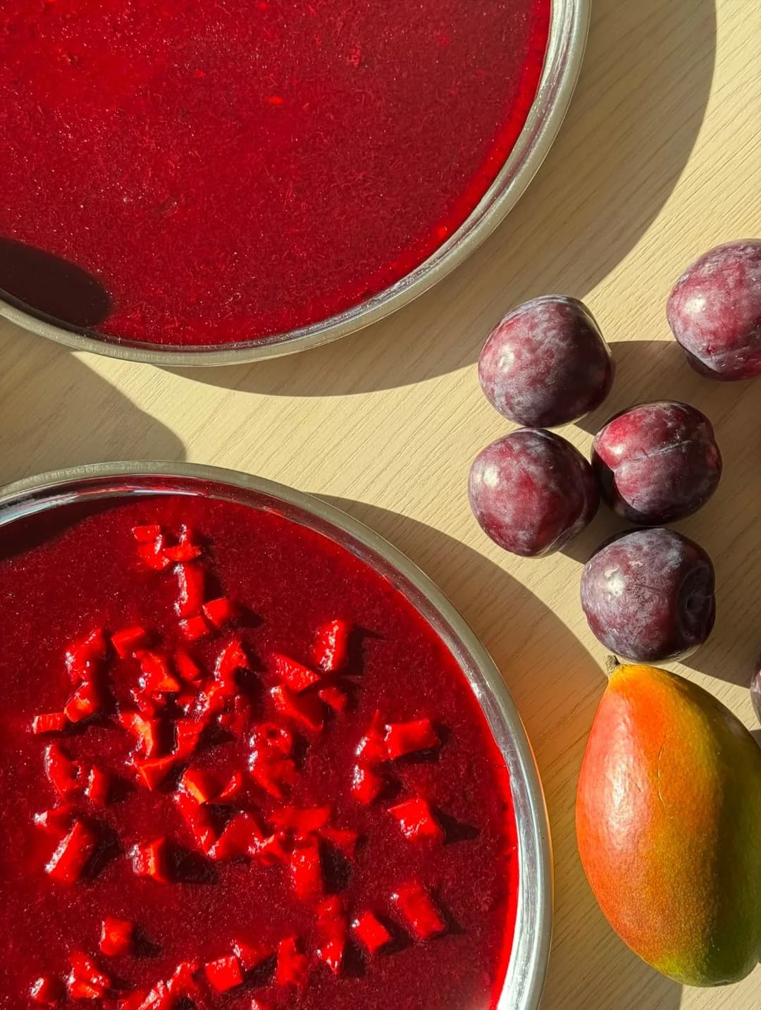 Plum purée being prepared beside fresh plums